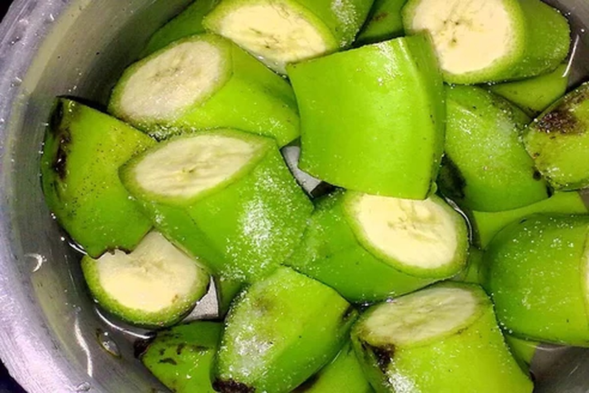 Banane ancora verdi, sbucciate e tagliate a pezzi in una ciotola d'acqua