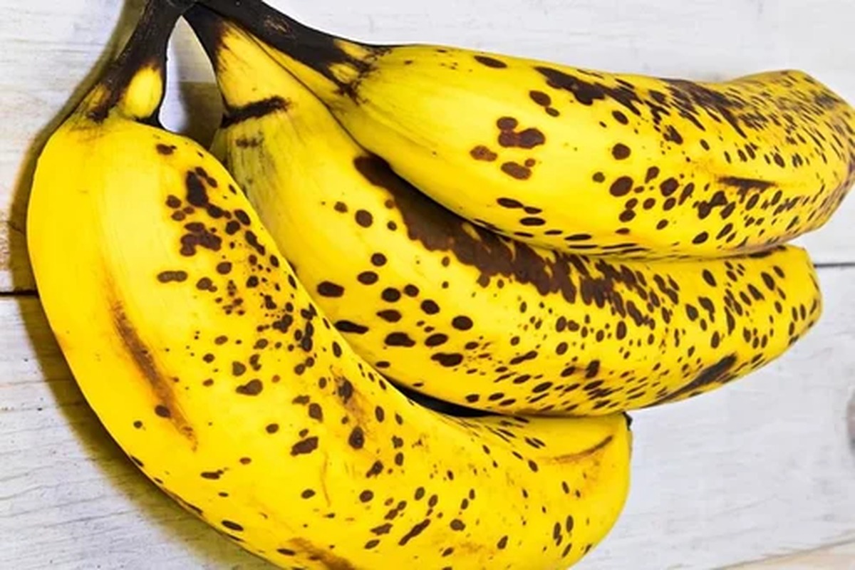 Casco di banane mature appoggiato su una superficie chiara